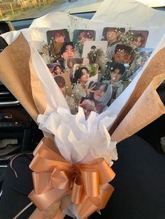 a bunch of pictures are wrapped in brown paper and tied to a car steering wheel