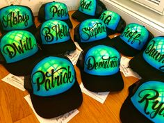 many hats are sitting on the floor with name stickers all over them in blue and black