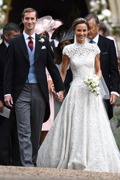 the bride and groom are holding hands as they walk down the aisle at their wedding