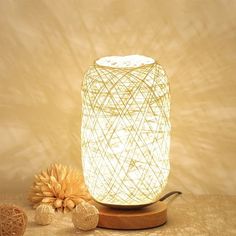 a white light sitting on top of a wooden table next to an orange flower and two balls