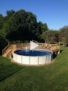 an above ground swimming pool in the middle of a grassy area with stairs leading up to it