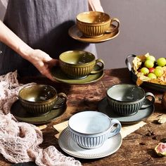 a table topped with plates and bowls filled with fruit next to a person holding a plate