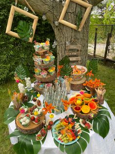 a table topped with lots of different foods and drinks on top of a white table cloth