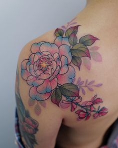 a woman with a flower tattoo on her shoulder