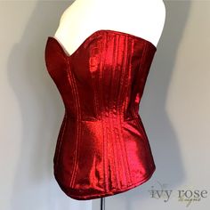 One of a Kind, this sample corset is created from a pattern drafted by Ivy Rose Designs to test techniques for metallic fabrics. For this reason, there are fewer vertical panels, and some unique horizontal seams to reduce the chances of the seams and fabric showing stress under tension.  It features a combination of internal and external bone channels, filled with spiral steels.  Made of an uber-shiny metallic red fabric, this is a stand-out piece! Finished garment measurements  bust 32" waist 2 Red Evening Corset With Boning, Red Strapless Corset With Corset Back, Red Fitted Bodice Corset For Party, Red Corset With Corset Back For Evening, Red Overbust Bodice With Boning, Red Overbust Boned Bodice, Red Boned Overbust Bodice, Red Corset With Boning, Red Fitted Corset With Boning