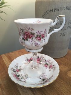 a cup and saucer sitting on top of a wooden table