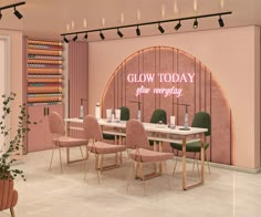 a room with pink walls and green chairs in front of a white table that says glow today