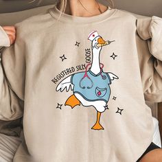 a woman wearing a sweatshirt with an image of a duck on it