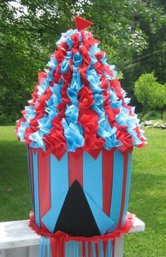 a red, white and blue cupcake cake sitting on top of a table in the grass