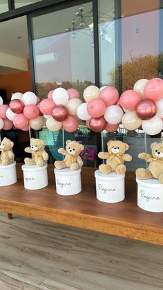 some teddy bears are sitting in small white pots with pink and white balloons behind them