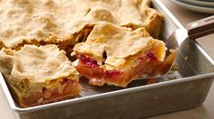 a close up of a pie in a pan on a table with a knife and fork