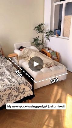 a man laying on top of a bed next to a white couch in a living room