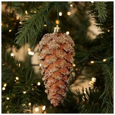 a pine cone ornament hanging from a christmas tree