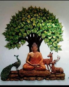 there is a buddha statue sitting under a tree with deers and birds around it