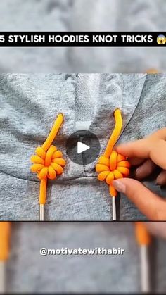 a person is holding two orange flowers on a toothpick with the words, this stylish hoodie knot tricks