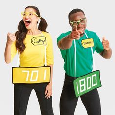 two people dressed in costumes and pointing at the camera with thumbs up signs on their faces