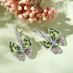 Add sparkle to your look with these butterfly-inspired earrings. Beautiful enamel design with vibrant colours and wings that'll define the Spirit of You. This intricate design is handcrafted using the legendary art of enameling, with sparkling stones that recreate the charm of the butterfly. Inspired by the beauty of nature, this will brighten up even the dullest of days in your life. Vibrant and full of life, these beautiful butterflies are ready to land in your jewelry box.Carat Weight: 0.49 c Multicolor Butterfly Earrings For Pierced Ears, Multicolor Butterfly Earrings, Multicolor Butterfly Charm Earrings, Butterfly Charm Wing-shaped Earrings For Gift, Multicolor Butterfly Charm Earrings As Gift, Butterfly Charm Earrings As Gift, Mystical Butterfly, Sterling Silver Drop Earrings, Silver Drop Earrings