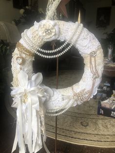 a white wreath decorated with pearls and lace