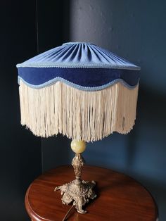 a table with a lamp on top of it next to a blue and white wall