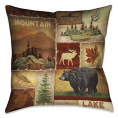 a decorative pillow with an image of a bear, moose and pine trees on it