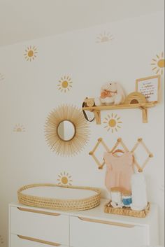 a baby's nursery room with sun decals on the wall and dressers