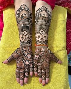 two hands with henna tattoos on them, one is showing off the intricate design