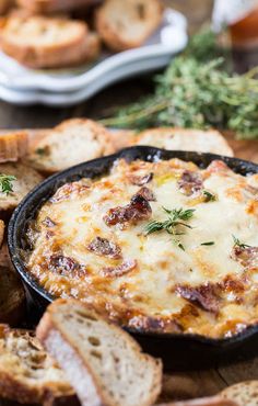 an image of bread and dip in a pan on a table with other food items