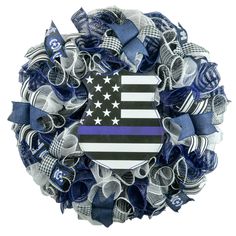 a blue and white wreath with an american flag on the front, surrounded by ribbons