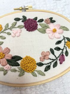 an embroidered floral design on a white cloth with gold trimmings and flowers in the center