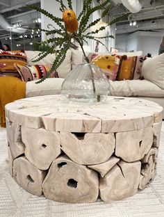 a table made out of logs with a vase on top