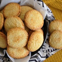 a bowl filled with cookies on top of a black and white cloth next to a yellow towel