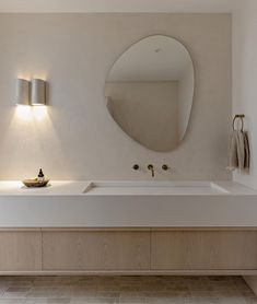 a bathroom with a sink, mirror and lights on the wall next to each other