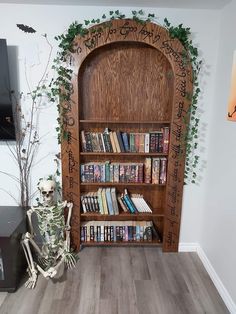 there is a book shelf with books on it and a skeleton sitting next to it