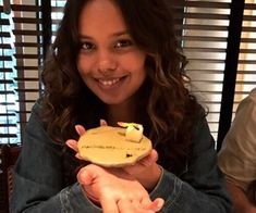 a woman holding a banana shaped object in her hands