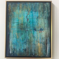 an abstract painting with blue and green colors on a white wall next to a black framed object