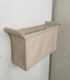 a close up of a curtain hanging on a wall with a cloth basket attached to it