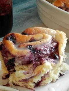 a piece of pie sitting on top of a white plate next to a bowl of fruit