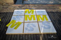 some yellow and white letters on top of a wooden floor next to other pieces of paper