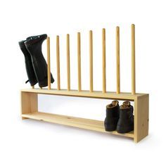 a pair of black boots sitting on top of a wooden shelf next to a boot rack