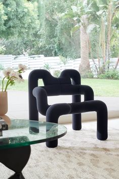 two black chairs sitting next to each other on top of a carpeted floor in front of a window