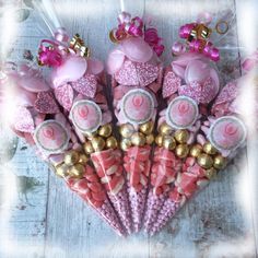 pink and gold candy sticks are arranged in a heart shape with bows on them,