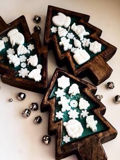 three wooden christmas trees with white frosting on them