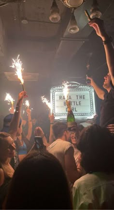 people holding up sparklers in front of a sign that reads razzle battle pub