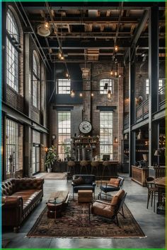 an industrial living room with large windows and lots of leather couches, coffee tables, and a clock on the wall