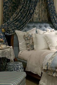 a bedroom with blue and white decor on the walls, bed linens and pillows