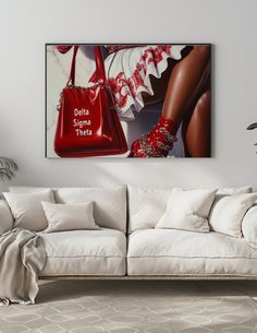 a living room with a white couch and red handbag hanging on the wall above it