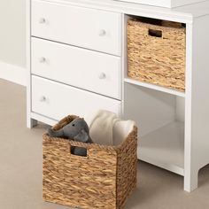 a white dresser with two baskets and a stuffed animal in it