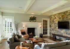 a living room filled with furniture and a flat screen tv mounted on the wall above a fire place