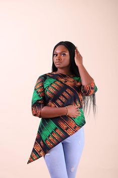 Show off your chic Afrocentric side with this 3/4-Sleeve top. This gorgeous African print women’s 3/4-sleeve top features a right-side slant for a flattering look. You can wear it with a variety of bottoms for versatile looks. Pair it with skinny jeans and heeled sandals for a stylish getup. DESCRIPTION: Standard Fit African print top High Low (Slanted on the right side) Unlined Invisible back zip 3/4 Sleeves Sleeve length 15 inch 100% cotton Model is 5'7 and wears US Size S Made in Nigeria FIT Tops African Print, African Print Top, Women Summer Tops, African Print Tops, African Designs, Dresses African, African Skirts, Trendy Tops For Women, African Dresses