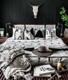 a bed with black and white decor on top of it next to a cow skull